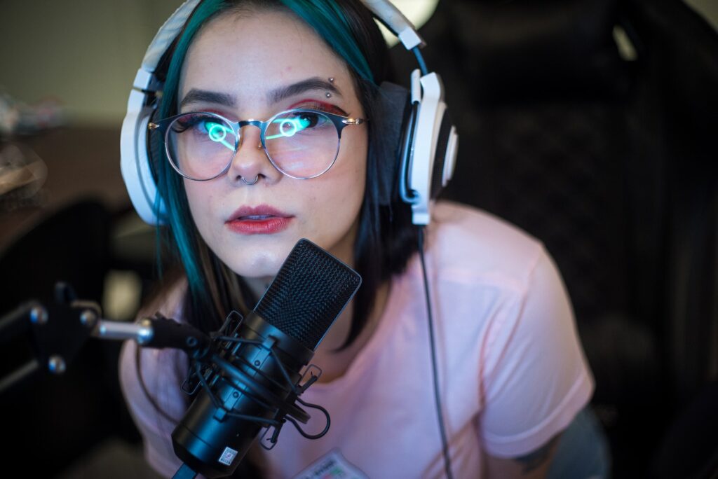 A person is sat in cenre frame with a ring light reflected in their glasses, their microphone is in front of them, checking your framing is important before you stream!