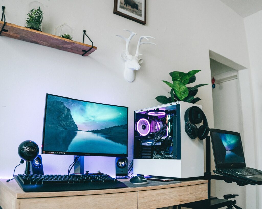 A dual PC streaming setup with a microphone on a desk next to the monitor which can help you secure your privacy while streaming to Twitch.