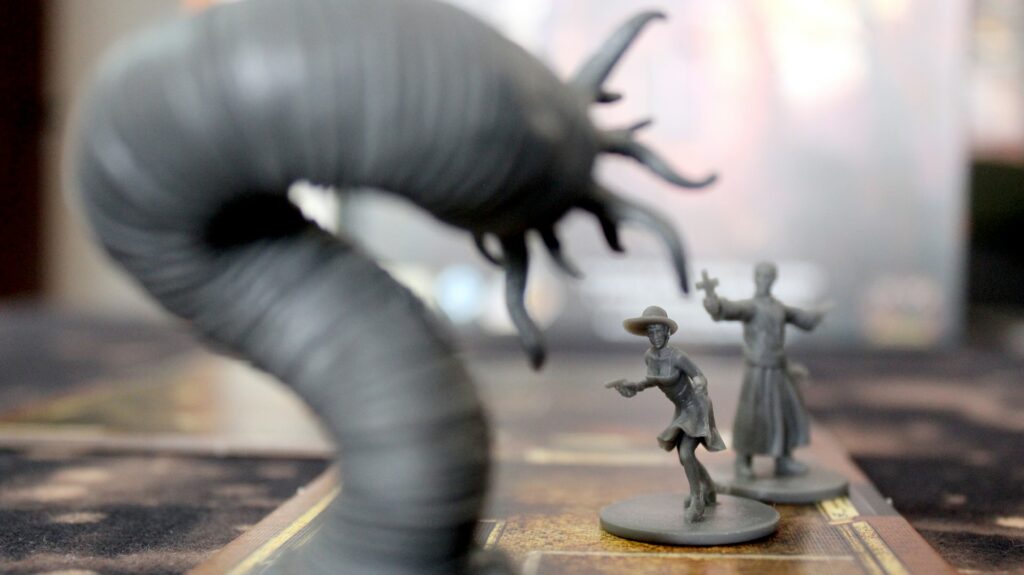 A close up of some miniature figures and a monster on a tabletop, things you might need to stream Dungeons and Dragons
  