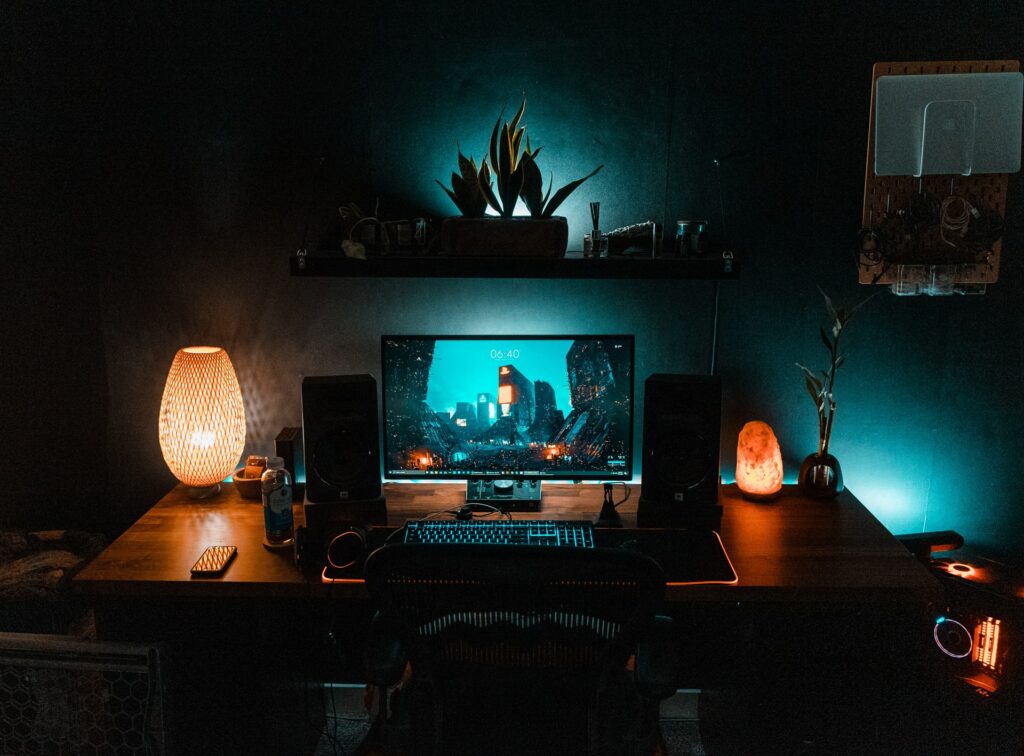 A streaming PC setup with speakers, a monitor, and moody lighting setup. Should you multistream your content?