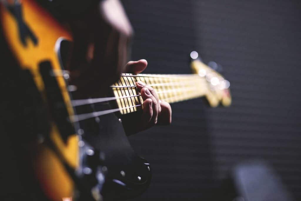 A bass guitar being played by a person who could live stream music