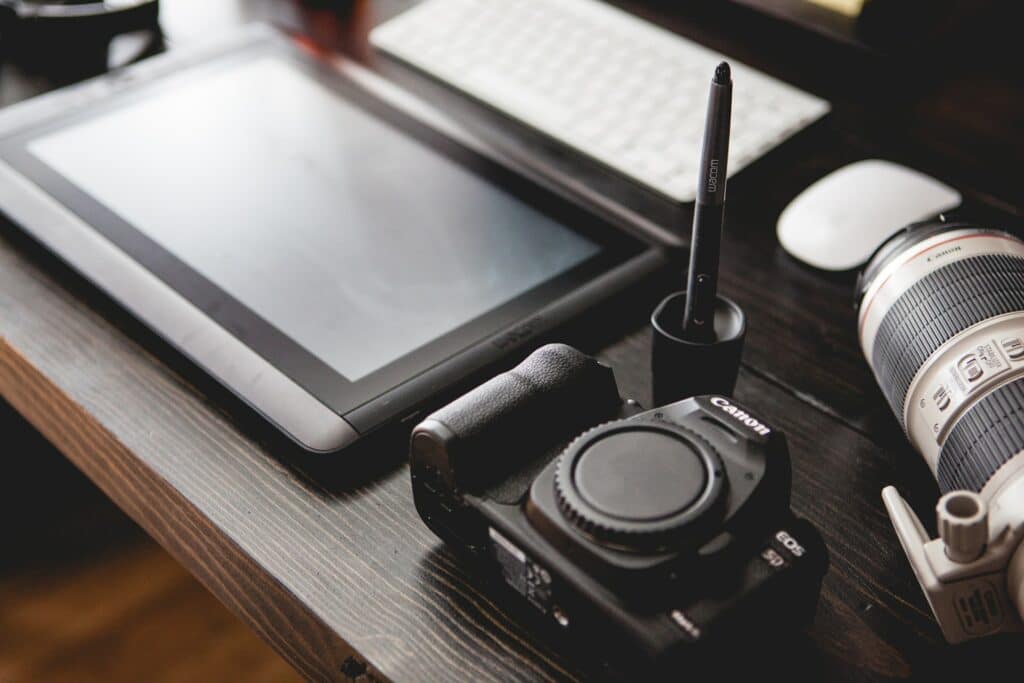 A digital art station with a computer, Wacom tablet and digital DSLR camers ready to be set up and stream digital art.