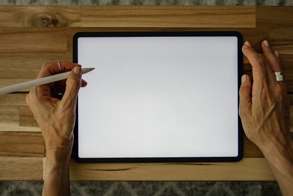 Someome at a table with an iPad and an Apple Pencil ready to stream digital art