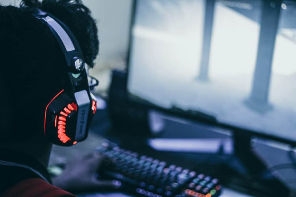 A person wearing an RGB gaming headset streaming on their gaming PC, adding live streaming automation could make their life easier.