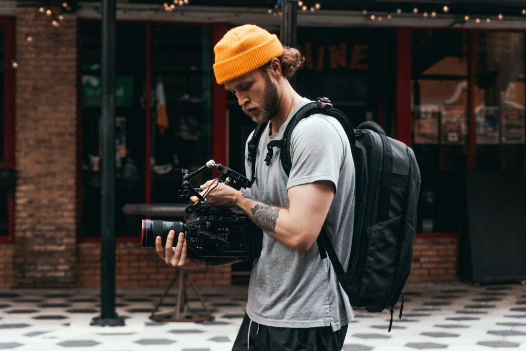 An IRL streamer using an expensive camera out on the streets connected to a backpack streaming setup is creating a narrative in order to get better at streaming.