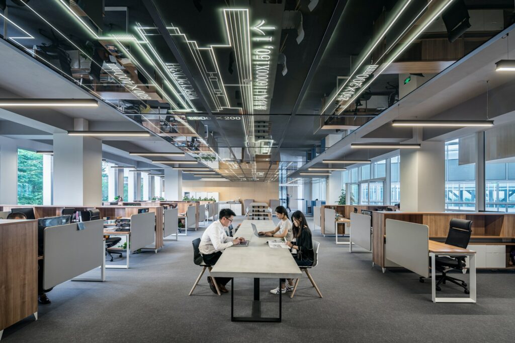 An open plan office with some people sat around a central table as a free webcam background