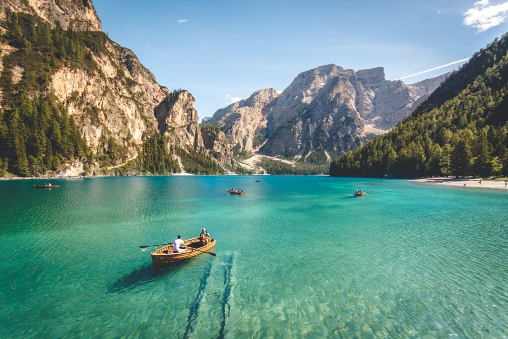 A boat on a lake next to some mountains as a free webcam backgrounds
