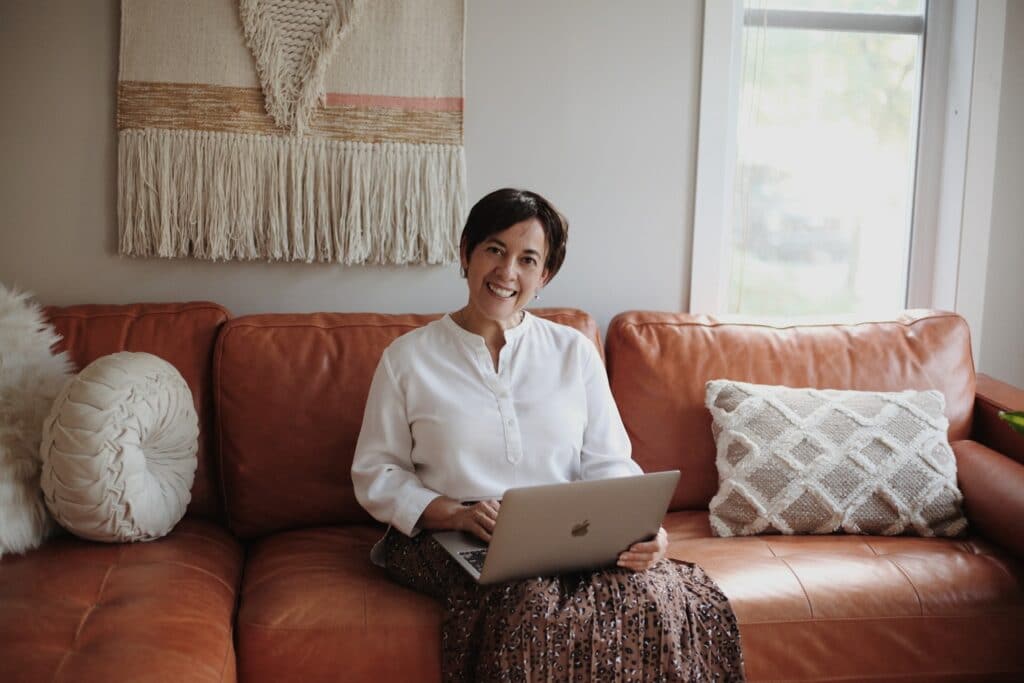 A remote worker smiling while working at home staying motived with remote team management.